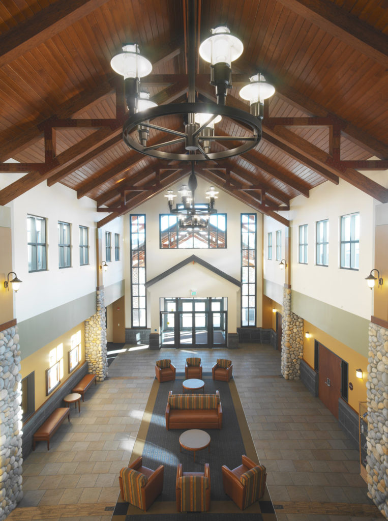 In a modern variation from historic wagon wheel light fixtures that simply have hanging lanterns from the spokes, these stylized reinterpretations grace the lobby upon entry