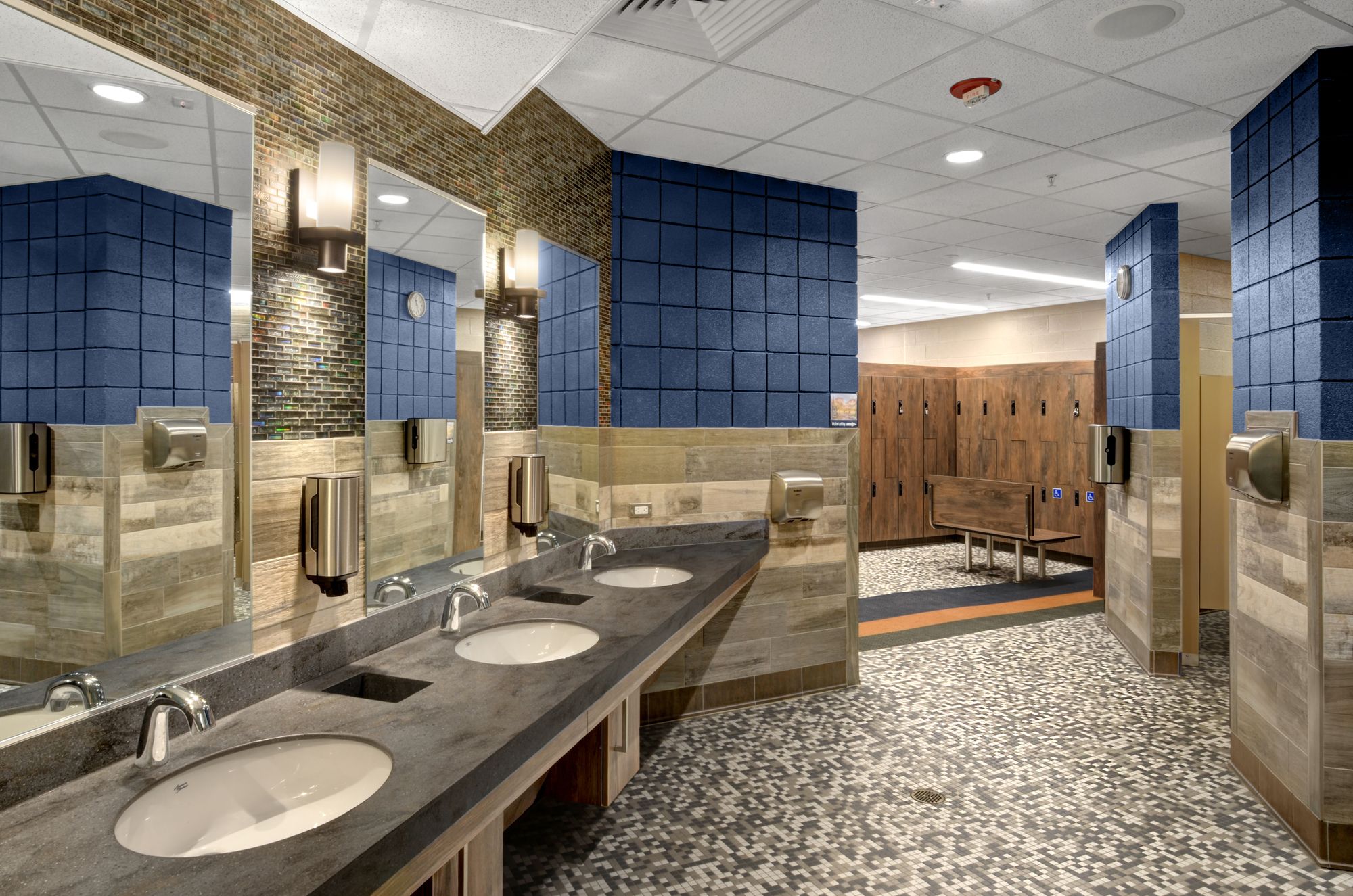 Upgraded illumination, patterned tile floor, wood tone tile wall, and wood locker all create a relaxing mountain environment at the Estes Valley Community Center in Estes Park, Colorado.